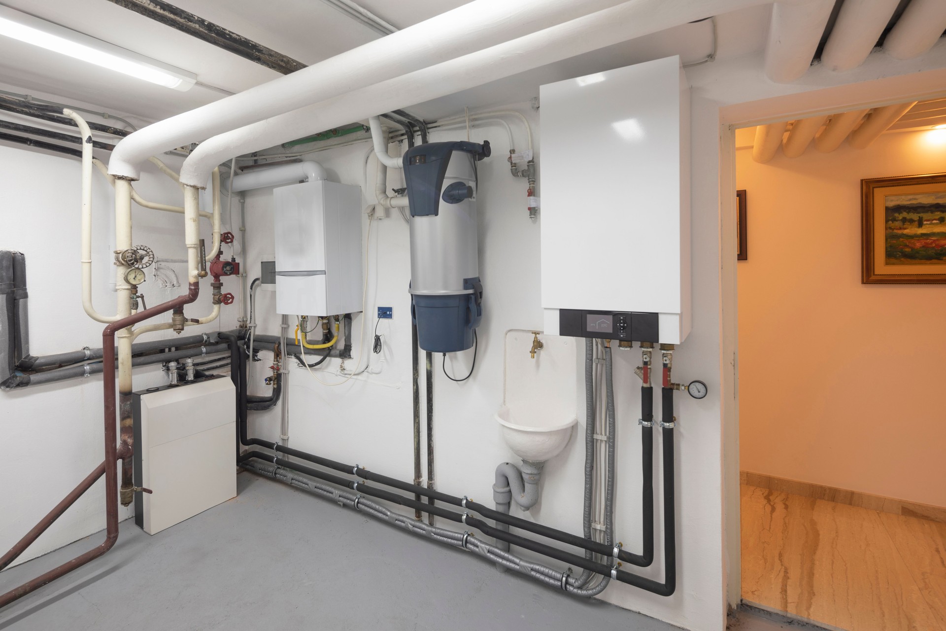 Technical room. Modern home, steam water heating system, gas boiler for central heating and cooling and hoover, vacuum cleaner machinery.